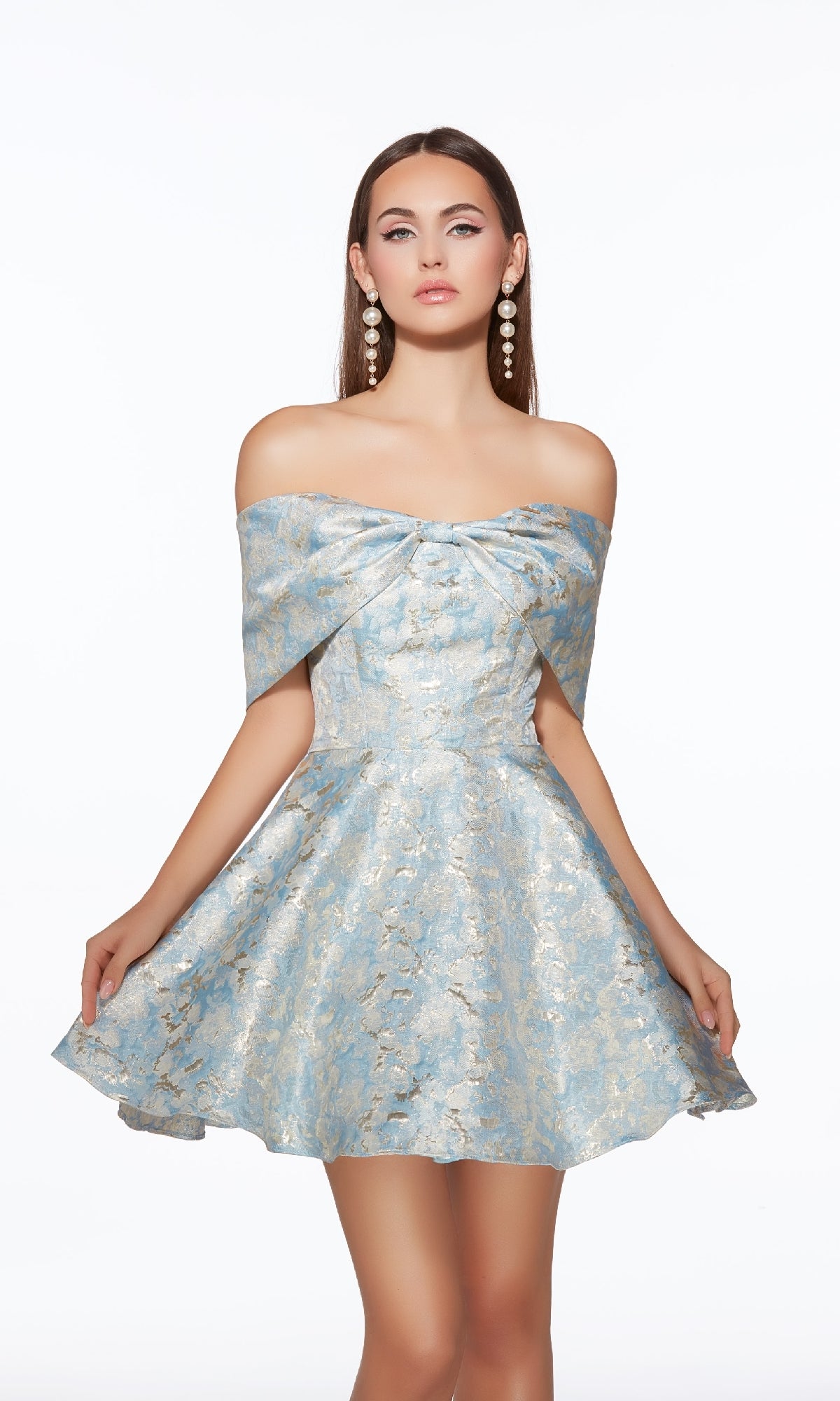 A woman models the Alyce 30046 short homecoming dress, featuring an off-the-shoulder blue and gold brocade pattern with a flared skirt, paired with large earrings, against a plain white background.
